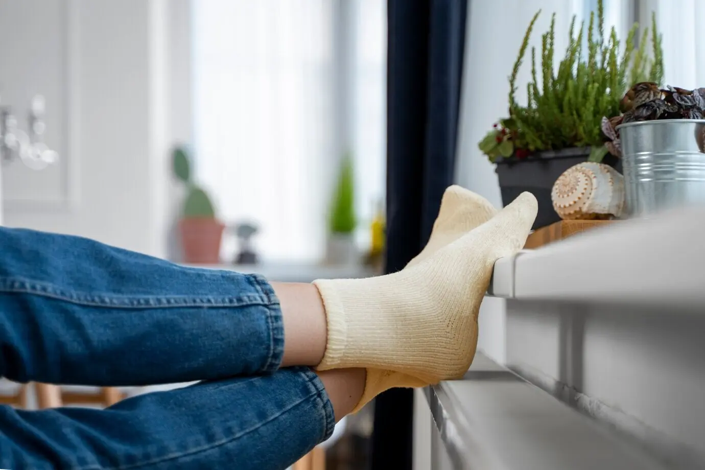 Close-up of feet lying on a heater.