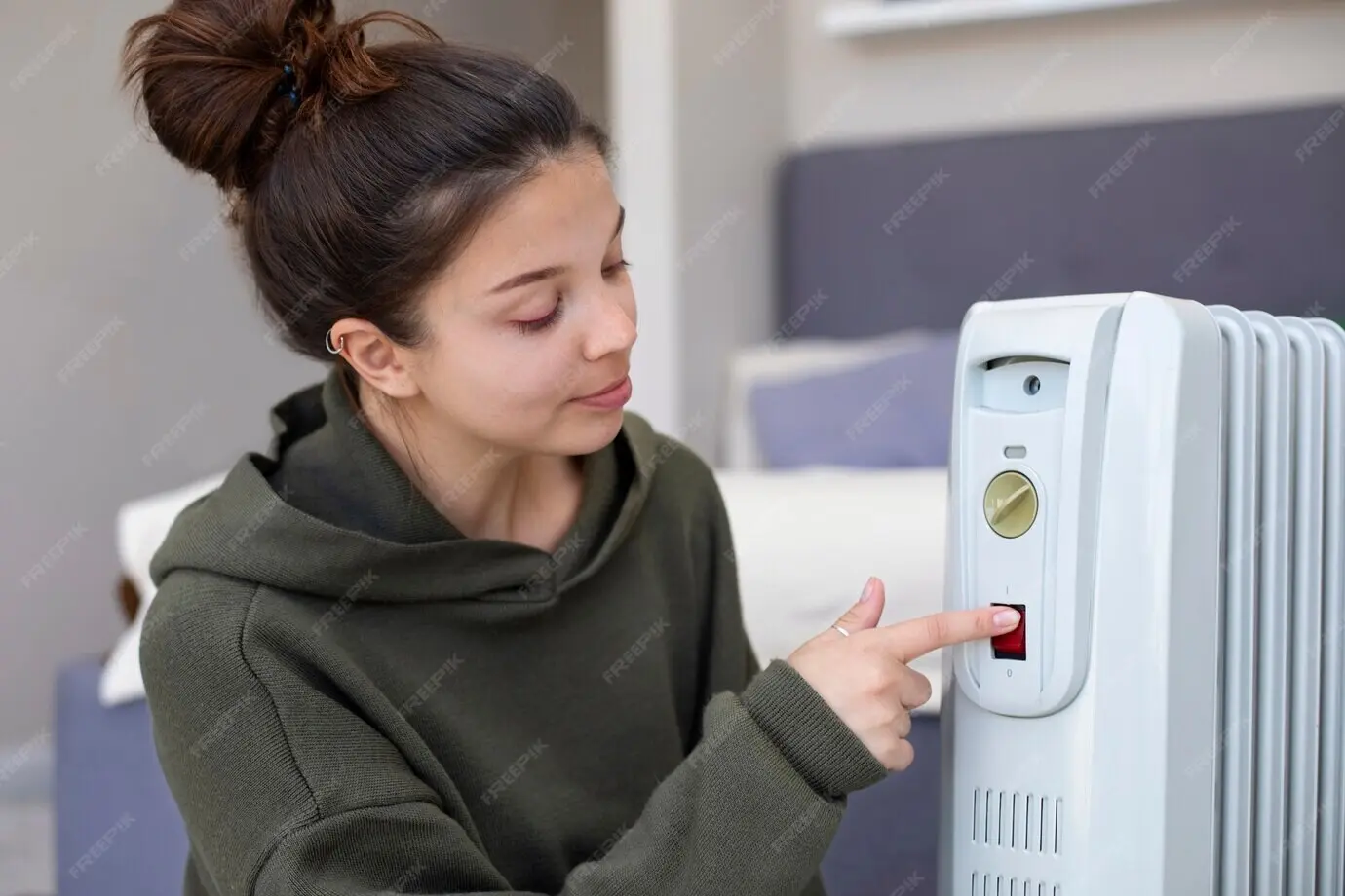 Medium shot of a woman pressing the heater’s red button.